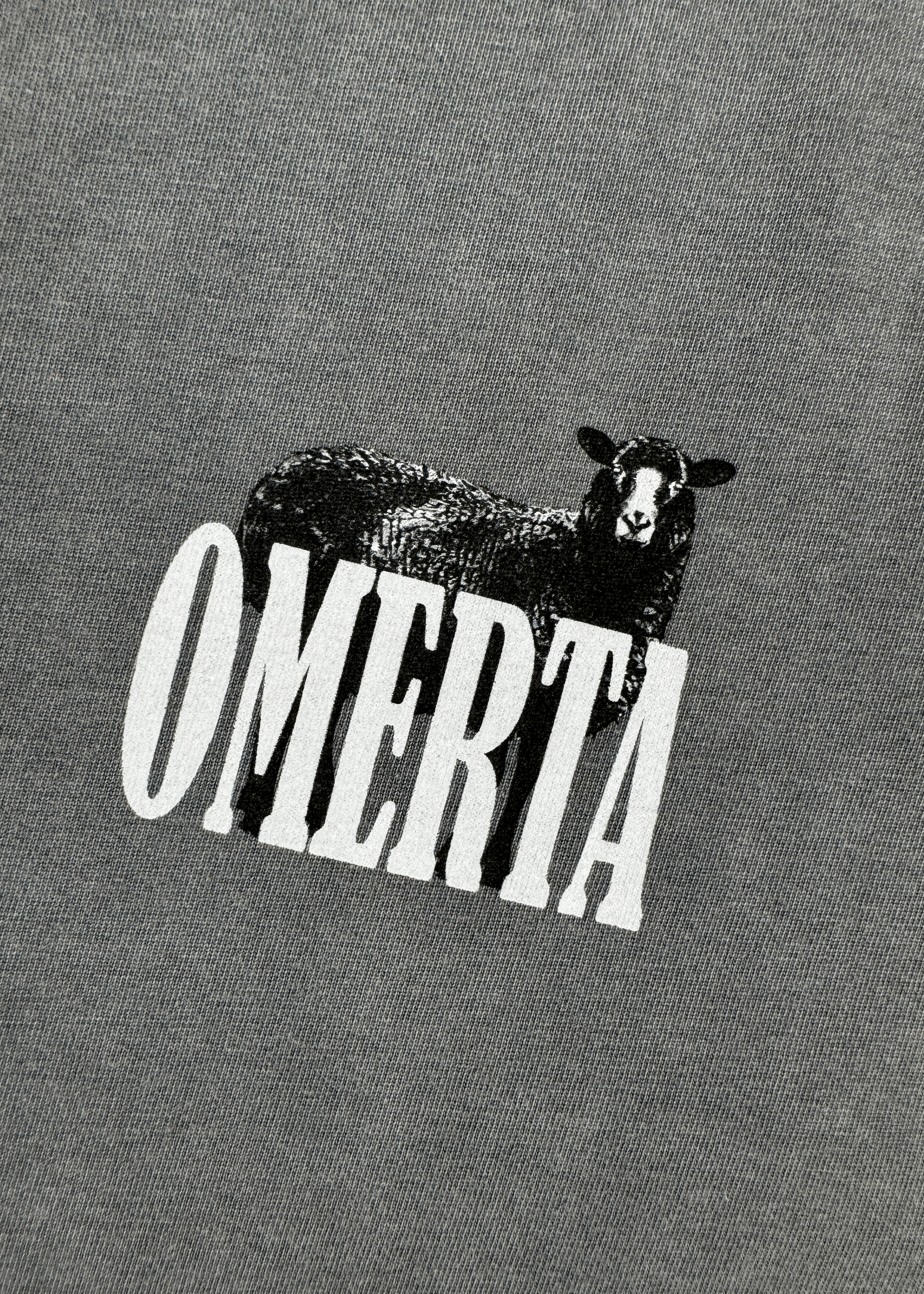 Close-up of Different Breed Tee logo - OMERTA with unique detailing.